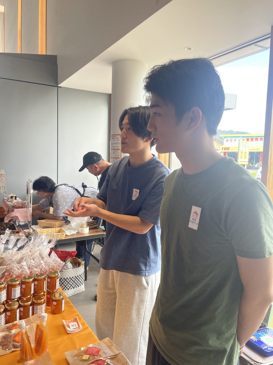 ちくまあんずフェアの売り場で、来場者に商品を説明しながら販売する学生