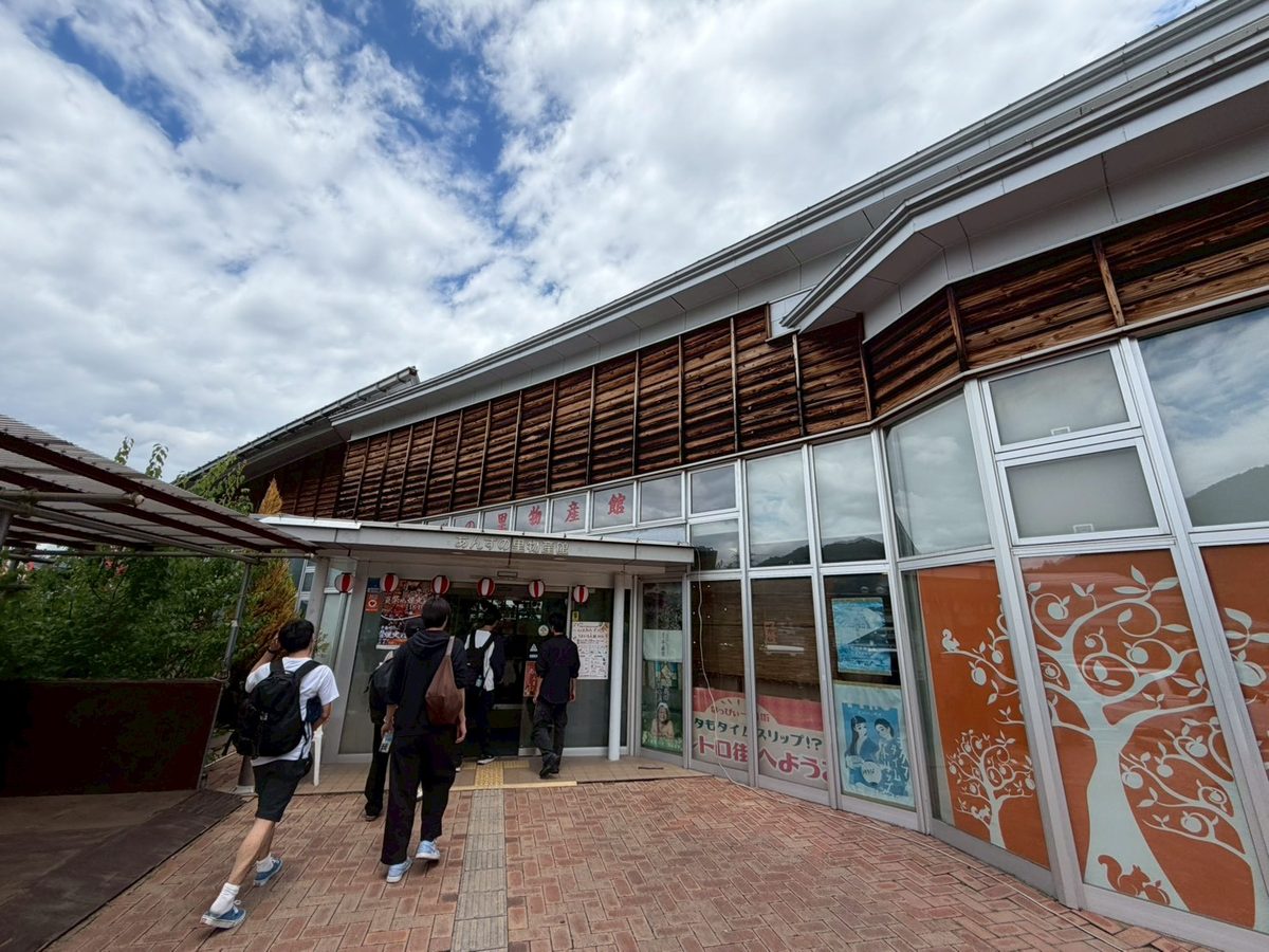 青空の下、あんずの里物産館へ歩く学生たち